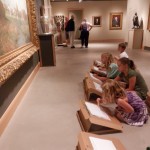 Young children at museum drawing their own rendition of a famous painting